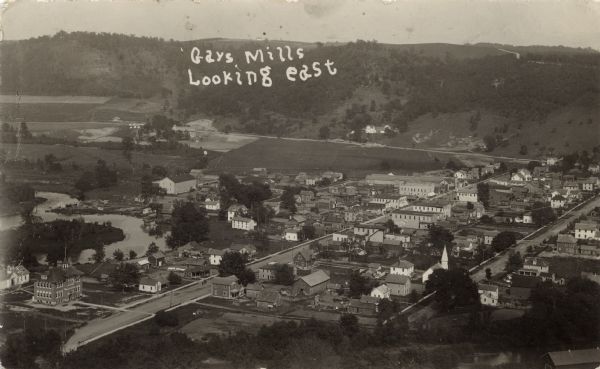 Elevated view of central Gays Mills. The school is in the lower left. A church is on the right. Caption reads: "Gays Mills, Looking East.: