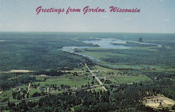 Color aerial postcard view of Gordon, with the St. Croix Flowage and the St. Croix River, and surrounding forests.