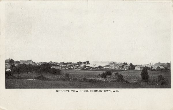 Slightly elevated view of Germantown from across a grassy field. Caption reads: "Birdseye [sic] View of So. Germantown, Wis."