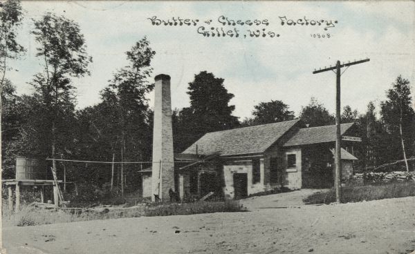 Exterior view of a butter and cheese factory with a brick smokestack. Monroe Done. — fix cataloging, add captions to description. Caption reads: "Butter & Cheese Factory, Gillett, Wis."