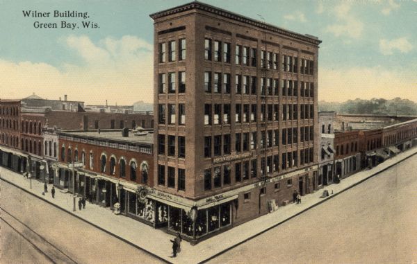 Elevated view of the Wilner Building, with six stories of commercial space. A clothing store is on the ground floor, and Northwestern Mutual Life Insurance is on the second floor. Caption reads: "Wilner Building, Green Bay, Wis."