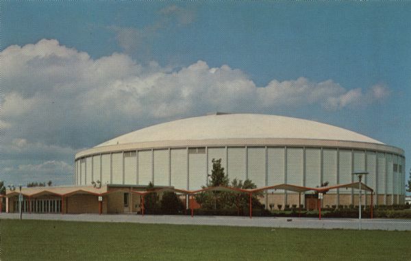 Color postcard of a domed sports and concert venue. A parking lot is in the front.