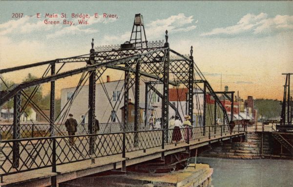 Illustrated postcard of an iron bridge over the Fox River with pedestrians crossing. The street on the far side is lined with businesses. Caption reads: "E. Main St. Bridge, E. River, Green Bay, Wis."