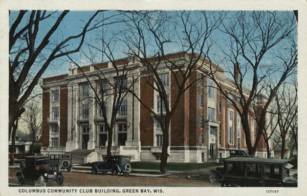 Colorized postcard view of a fraternal lodge building. Automobiles are parked along the curbs. Caption reads: "Columbus Community Club Building, Green Bay, Wis."