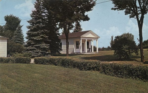 Color postcard of a small, white building with columns at the entrance.

Text on reverse reads: "Henry Baird, first attorney, Territorial Attorney General, giant of territorial and early statehood days built this little office building in 1831."