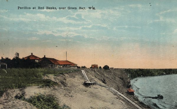 Colorized postcard of a beachside pavilion and the long, wooden staircase leading down to the waterfront. Caption reads: "Pavilion at Red Banks, near Green Bay, Wis."
