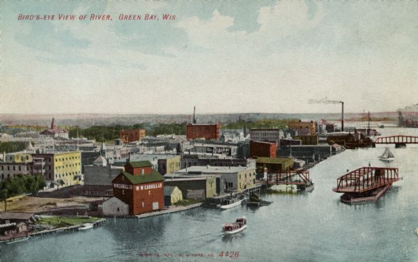 Colorized postcard of the Fox River and the buildings along the waterfront. The bridge in the foreground has a movable center section. Caption reads: "Bird's-Eye View of River, Green Bay, Wis."