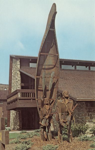 Color reproduction of a metal sculpture of two explorers standing near upended canoe.

Text on reverse reads:
"The First Northern Voyageurs
Sculpture by Lyndon Fayne Pomeroy
First Northern Savings and Loan
Corner of Cherry Street and Monroe, Green Bay, WI
Erected by First Northern Savings as a historical gift to Northeastern Wisconsin, this sculpture is a tribute to the fearless French explorers and fur traders who pioneered settlement of Northeastern Wisconsin. This magnificent sculpture rises 30 feet into the air and is a well-known Green Bay Landmark."