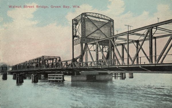 View across water towards the Walnut Street Bridge, a bascule bridge spanning the Fox River. Caption reads: "Walnut Street Bridge, Green Bay, Wis."