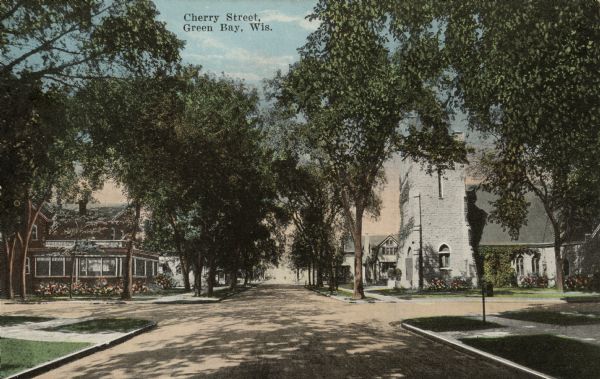 View of a tree-lined neighborhood street with a church on the right and a house on the left. Caption reads: "Cherry Street, Green Bay, Wis."