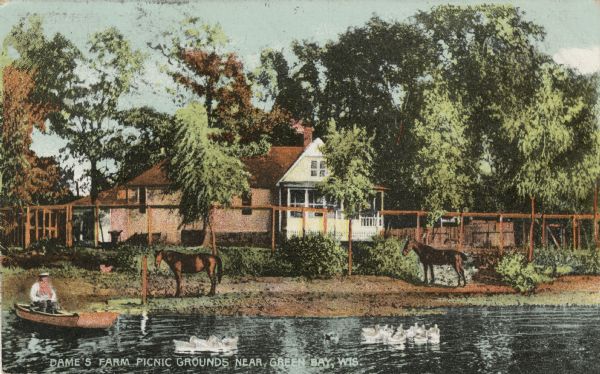 View across water towards a dwelling on the shoreline. Horses are on the shore, ducks are in the water, and a man is in a rowboat. Caption reads: "Dames Farm Picnic Grounds Near Green Bay, Wis."