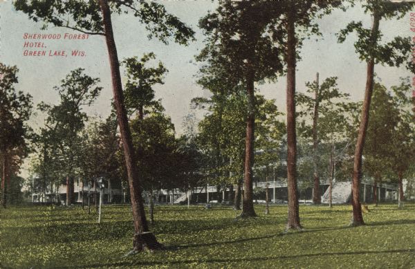 View across lawn towards a three-story hotel obscured by trees. Steps lead up to the second level which has a porch. Caption reads: "Sherwood Forest Hotel, Green Lake, Wis."