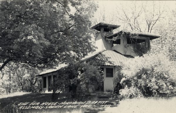View of the tea house surrounded by shrubs and trees. Caption reads: "The Tea House — Northern Baptist Assembly — Green Lake, Wis."
