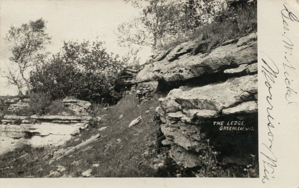 View of a stone ledge rock formation. Caption reads: "The Ledge, Greenleaf, Wis."