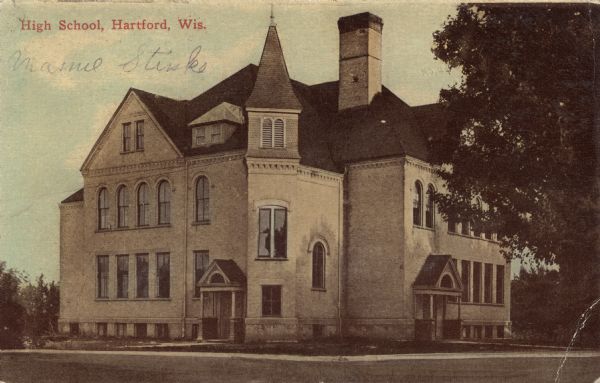 View of the high school, a three-story brick building with arched windows on the second floor. Caption reads: "High School, Hartford, Wis."