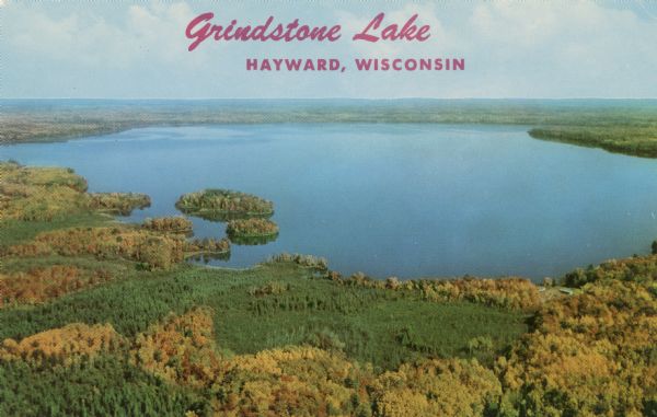 Aerial view of Grindstone Lake and fall foliage. Text on reverse reads: "One of Hayward's most beautiful lakes, noted for world-record muskies, and white sandy beaches."