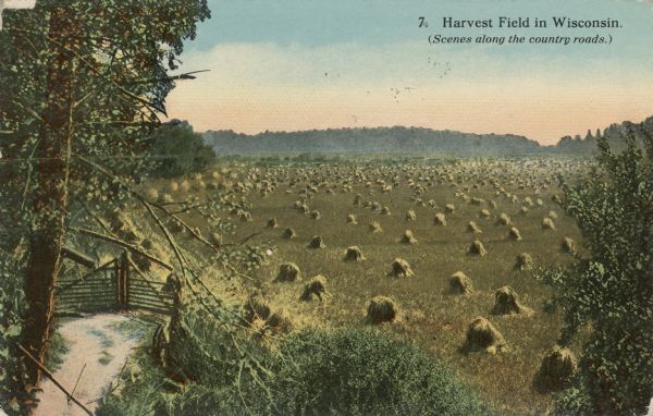 Subtitled: "(Scenes along the country roads.)" Hand-colored view of a field with harvested hay. A road and entry gate are on the lower left.