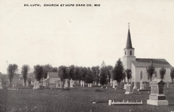 The Evangelical Lutheran Church with a cemetery in the churchyard. Caption reads: "Ev. Luth. Church at Hope, Dane Co., Wis."  Also known as Hope Lutheran Church.  This building was destroyed by fire in 1973.  New church building dedicated in 1974.