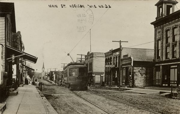 View of Main Street lined with businesses on both sides. A streetcar is approaching. Caption reads: "Main St., Horicon, Wis."