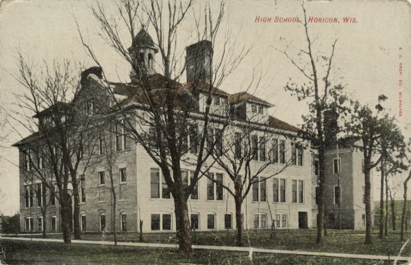 Exterior view of the high school. Trees on the grounds are bare of leaves. Caption reads: "High School, Horicon, Wis."