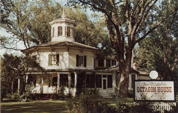 Color postcard of an octagonal house.

Text on reverse reads: "The Historic Octagon House
Hudson, Wisconsin
Erected in 1855 at 1004 3rd St. A fine example of the octagonal style which swept the U.S. in the 1850s. The house and its authentic furnishings represent the mid-19th century. A former carriage house adjacent to the Octagon House serves as a museum. Open to visitors certain hours."