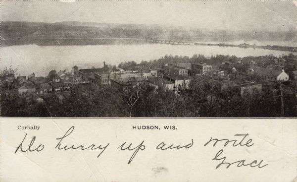 Elevated view of Hudson and the St. Croix River. The Interstate Bridge is spanning the river. Caption reads: "Hudson, Wis."