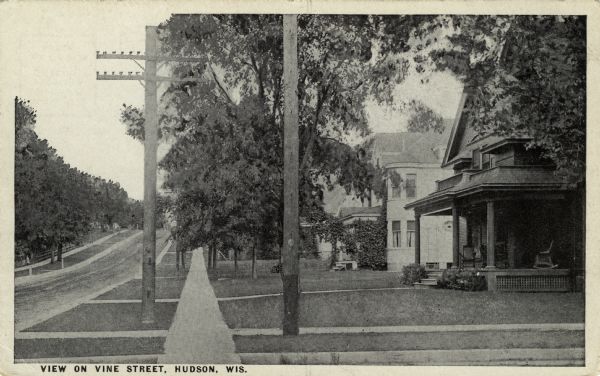 View of a tree-lined residential street with two and three-story, single-family homes. Caption reads: "View on Vine Street, Hudson, Wis."