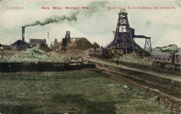 View of the Cary iron Mine. Railroad tracks are in the right foreground. Caption reads: "Cary Mine, Hurley, Wis."