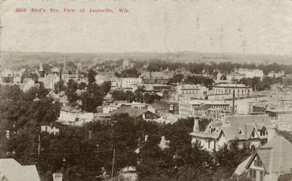 Elevated view of the skyline of central Janesville and surrounding landscape. Caption reads: "Bird's Eye [sic] View of Janesville, Wis."
