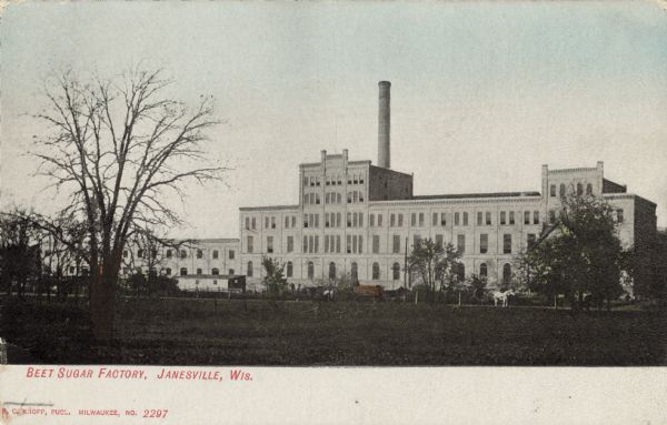 View across field toward the beet sugar factory. Caption reads: "Beet Sugar Factory, Janesville, Wis."
