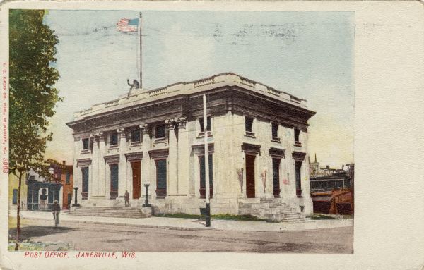 View of the neo-classical post office building. There is a flag on a flagpole on the roof. Caption reads: "Post Office, Janesville, Wis."