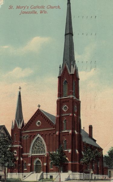 Colorized view of a Catholic church with tall steeple and bell tower. A large, arched window is above the entrance. Caption reads: "St. Mary's Catholic Church, Janesville, Wis."