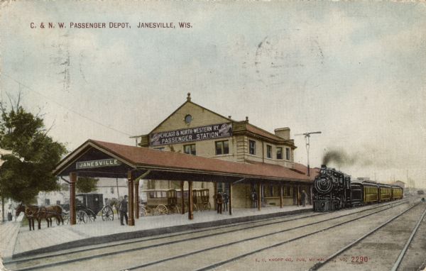 View of the Chicago and Northwestern Passenger Station. Horses and coaches are at the curb. A train is pulling up to the station, and men are standing on the platform. Caption reads: "C. & N. W. Passenger Depot, Janesville, Wis."