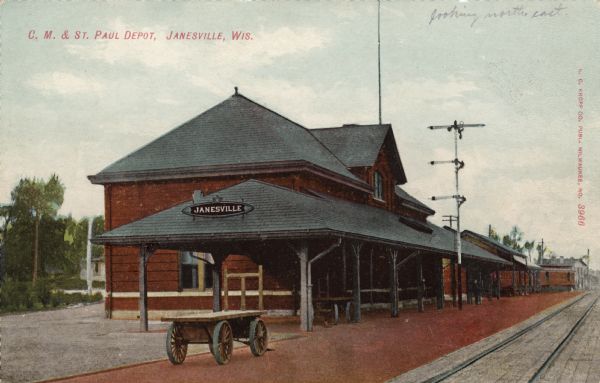View across railroad tracks toward the C. M. & St. Paul Depot. Caption reads: "C. M. & St. Paul Depot, Janesville, Wis."