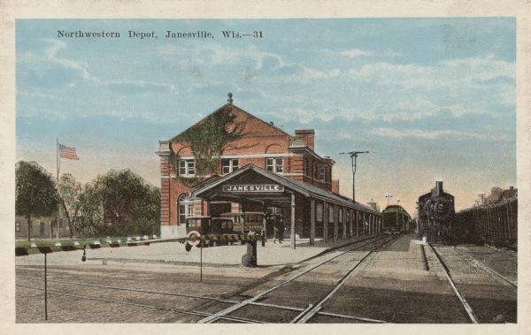 View across railroad tracks toward the Northwestern Railroad Depot in Janesville. Trains are on the tracks and automobiles are parked at the curb. Caption reads: "Northwestern Depot, Janesville, Wis."