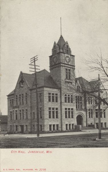 View across intersection toward the City Hall with a clock tower and an arched entrance. Caption reads: "City Hall, Janesville, Wis."