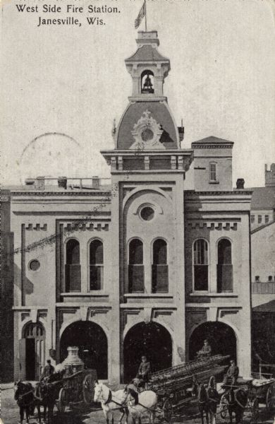 Elevated view of a fire station with men on horse-drawn fire wagons in front. One wagon has a pump; the other has ladders. Caption reads: "West Side Fire Station, Janesville, Wis."