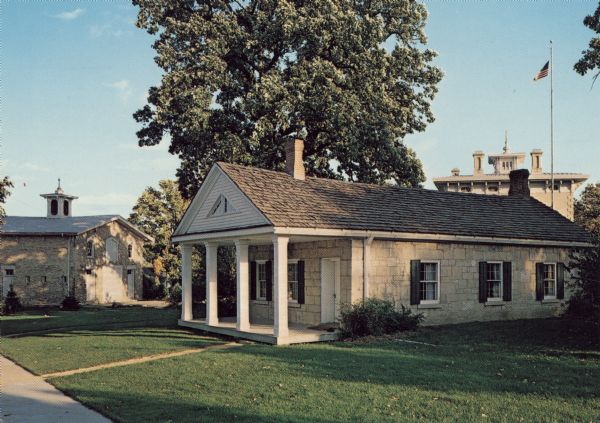 Color postcard of a Greek Revival House - one of the earliest permanent residences in Janesville.
