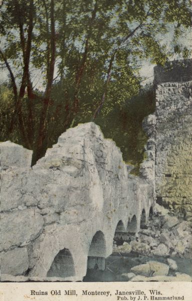 View of what's left of the ruins of a mill, with concrete arches over the water, and a stone wall. Caption reads: "Ruins Old Mill, Monterey, Janesville, Wis."
