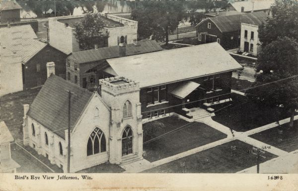 Elevated view of the public library and the church next door. Caption reads: "Bird's Eye View Jefferson, Wis."