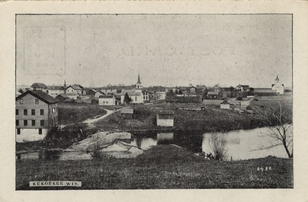View of Kekoskee from across the Rock River. Caption reads: "Kekoskee, Wis."