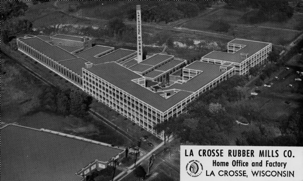 Aerial view of the mills. Caption reads: "La Crosse Rubber Mills Co., Home Office and Factory, La Crosse, Wis." Text on reverse reads: "NOTE: This is an aerial view of our La Crosse, Wisconsin factory where the fine line of LA CROSSE RUBBER FOOTWEAR is made. On this very spot Indians used to war and play."
