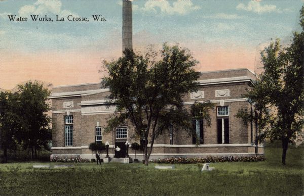 Exterior view of the water works building. Flowers are planted along the front, and lampposts are flanking the entrance. Caption reads: "Water Works, La Crosse, Wis."