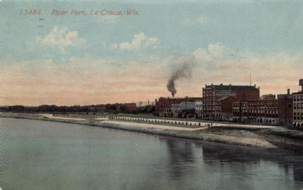 View across Mississippi River towards a riverside park. Buildings are along the right behind the park. Caption reads: "River Park, La Crosse, Wis."