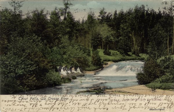 View of Trout Falls. On the left bank is a group of women. Caption reads: "Trout Falls, La Crosse River, La Crosse, Wis." Bottom right text reads: "Handcolored".