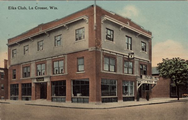 View across intersection towards the Elk's Club. Antlers are mounted on the brick wall between the second and third story on the corner of the building. Caption reads: "Elks Club, La Crosse, Wis."