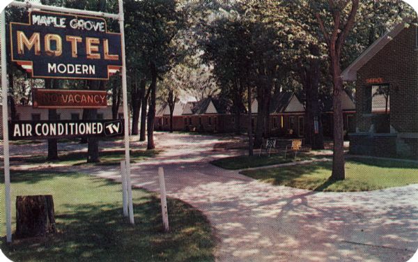 View of the entrance driveway to the Maple Grove Motel. An electric sign for the Motel is on the left.

Text on reverse reads: "Maple Grove Motel, 34 Modern Units, TV & Air Conditioned, Restaurant & Cocktail Lounge Adjoining, 2 Miles South of La Crosse on U.S. Highways 14-61-35, Open All Year Around, Phone 4-6344"