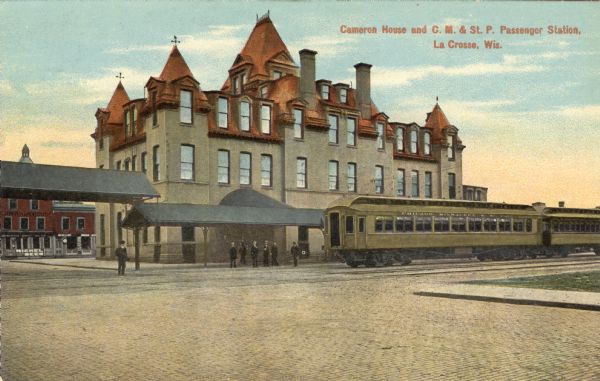 View of the Cameron House hotel and the railroad platform. Caption reads: "Cameron House and C. M. & St. P. Passenger Station, La Crosse, Wis."