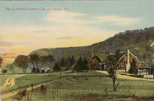View of the Country Club and grounds. Bluffs are in the background. Caption reads: "The La Crosse Country Club, La Crosse, Wis."