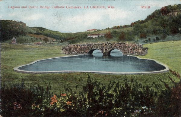 Hand-colored view of the lagoon and stone bridge in the Catholic Cemetery. Caption reads: "Lagoon and Rustic Bridge, Catholic Cemetery, La Crosse, Wis."